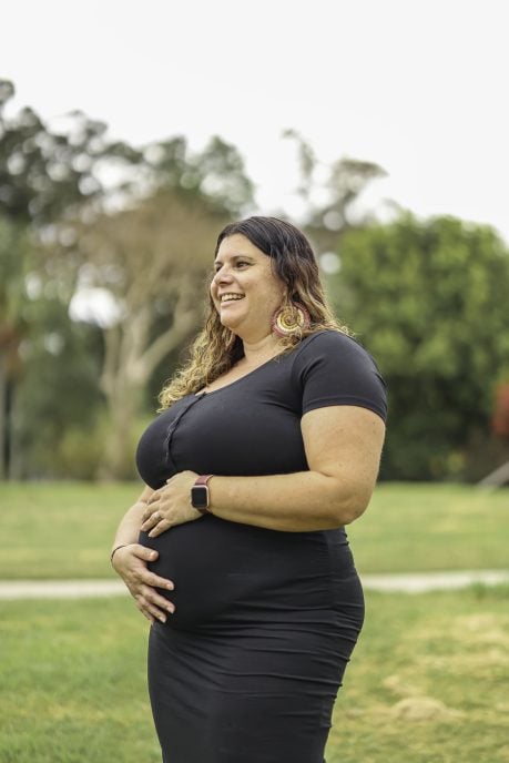 First Nations woman cradling her baby bump